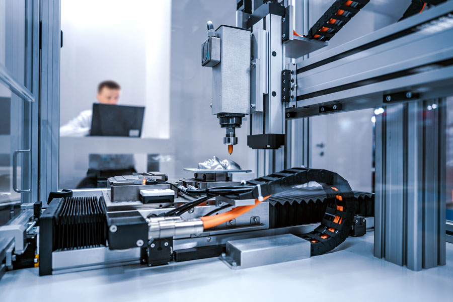 CNC-laserskärning av metall med fleraxligt linjärsystem och operatör i bakgrunden – eventuellt levererad av en Bosch Rexroth Partner.
